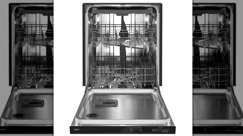 A close-up of a dishwasher interior with dishes and a bowl of vinegar